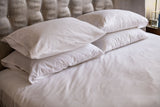 A bed made with Thomaston T180 Sheets and Pillowcases.